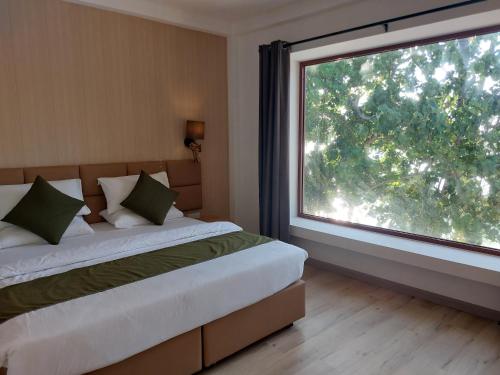 a bedroom with two beds and a large window at Comfy Cool Breeze by eMzaz in Dhiffushi