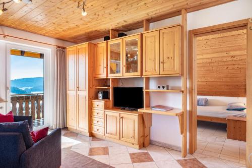 a room with a desk with a television and a bed at Lorenzenhäusle Titisee-Neustadt in Titisee-Neustadt
