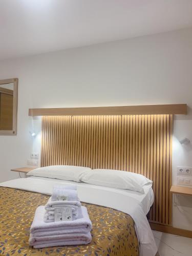 a bedroom with a large bed with towels on it at Fuentes de luz in San Sebastián de los Reyes