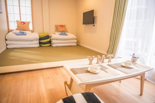 a room with a table and a pile of towels at 和の宿ホテルYamatoinn Akihabara#401 in Tokyo