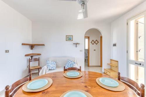 a table with four plates on it in a living room at Casa vacanze torre vado in Marina di Pescoluse