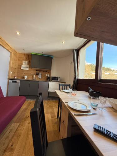 une cuisine et un salon avec une table dans une pièce dans l'établissement Le 3300 - 42 - Studio vue piste - 2 pers, à Les Deux Alpes
