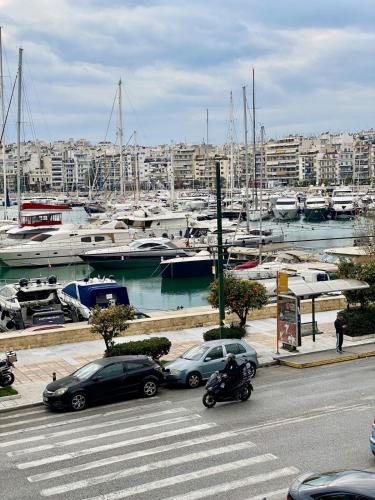 een groep auto's geparkeerd bij een jachthaven met boten bij Cozy Apartment View Pasalimani in Piraeus