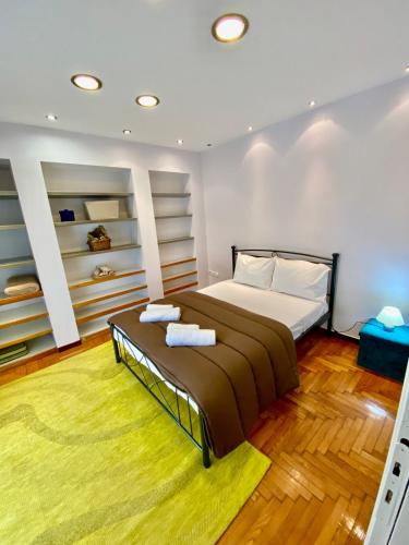 een slaapkamer met een groot bed en een geel tapijt bij Cozy Apartment View Pasalimani in Piraeus