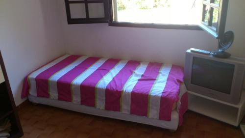 - une petite chambre avec un lit et une télévision dans l'établissement Vermentinu T1 bis 50 m plage du Ruppione, à Pietrosella