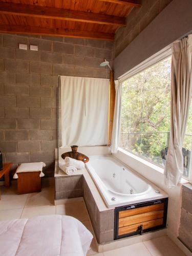 a large bathroom with a tub and a window at Alma Tierra in Merlo