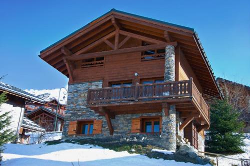 a log cabin with a balcony on top of it at Chalet Le Panicaut in Levassaix