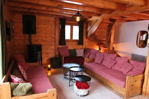 a living room with a purple couch in a cabin at Chalet Le Panicaut in Levassaix