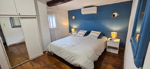 - une chambre dotée d'un mur bleu et d'un lit avec des oreillers dans l'établissement Lea-Vue mer panoramique- clim-Wifi- plage à pieds, à Conca