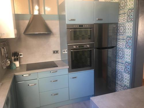 a kitchen with white cabinets and a refrigerator at Appartement Plage Malo les bains avec confort in Dunkerque