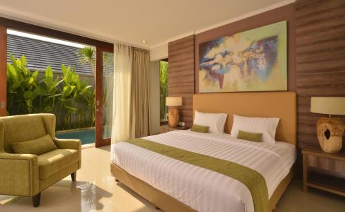 a bedroom with a large bed and a chair at Sotis Villas Canggu in Canggu