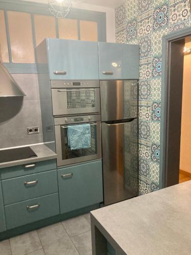 une cuisine avec un réfrigérateur en acier inoxydable et un comptoir dans l'établissement Appartement Plage Malo les bains avec confort, à Dunkerque