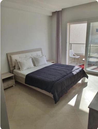 a bedroom with a large bed and a large window at Dar Kmar 2 in Tunis