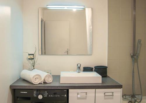 a bathroom with a sink and a mirror at Spacious home near Canal and Stadium with Wifi in Reims