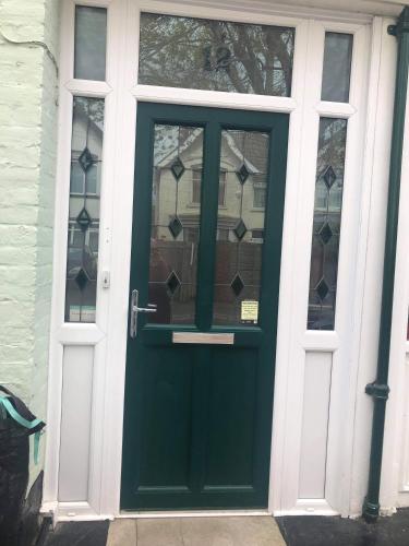 a green door with windows on a house at The Seagulls 3 Bedroom House with Parking Weymouth in Weymouth