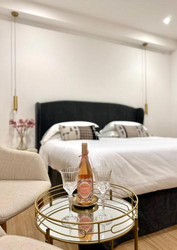 a bedroom with a bed and a table with glasses on it at Feel Boutique Rooms in Oristano