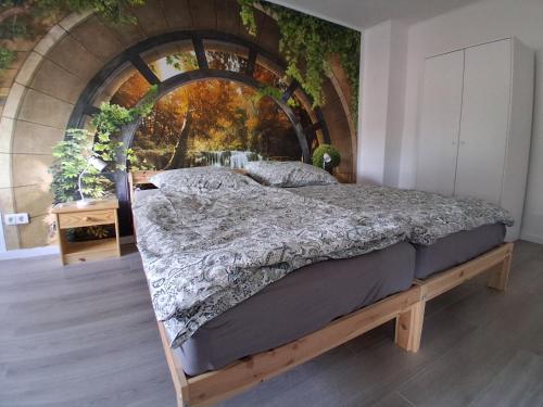 a bedroom with a bed in a room with a wall at Pension Ronnys wilde Wiese in Belgershain