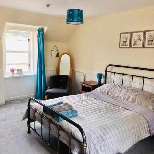 a bedroom with a bed and a chair and a window at Lettoch Farm in Dufftown