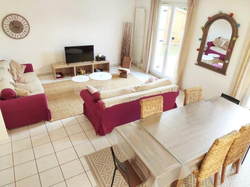 un salon avec une table et un canapé dans l'établissement Villa Chic and Cosy near Versailles, à Bois-dʼArcy