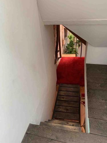 a stairway with a red couch and a red carpet at Le Cent dix-sept in Saint-Valery-sur-Somme