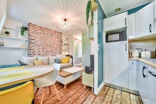 une cuisine et un salon avec une table et un canapé dans l'établissement The apartment in the trees Lille, à Lille