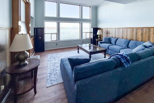 Una sala de estar con un sofá azul y una mesa. en Captain’s Quarters, en Clinton