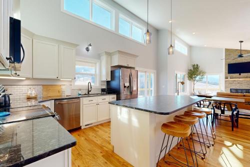 a kitchen with white cabinets and a black counter top at Hillside Escape in Waynesville