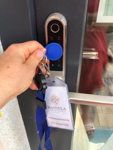a person is holding a key to a machine at Mandula Apartman in Cegléd