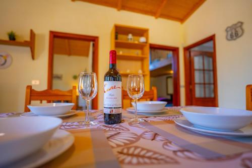 a bottle of wine sitting on a table with two glasses at Casa Rural Buda Terra in Santa Cruz de Tenerife