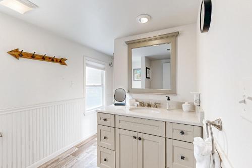 a white bathroom with a sink and a mirror at Ann Acres --- 21069 Elizabeth Ave. in Rehoboth Beach
