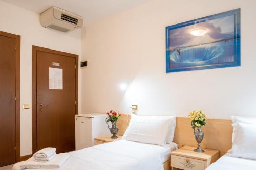 a hotel room with two beds and a picture on the wall at B&B New Aurora Venice in Marghera