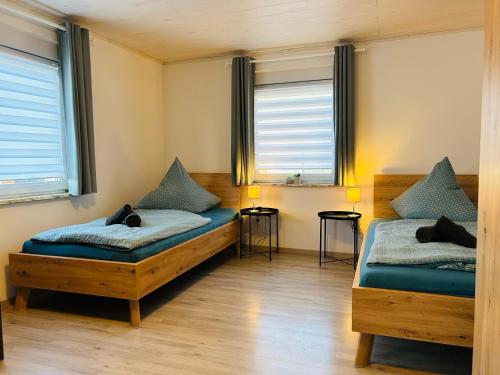 two beds in a room with two windows at Ferienhaus Trockau für 10 Personen in Pegnitz