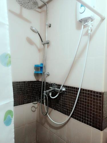 a shower with a hose in a bathroom at 1BEDROOM CONDO AZALEA WITH FREE WIFI in Tabok