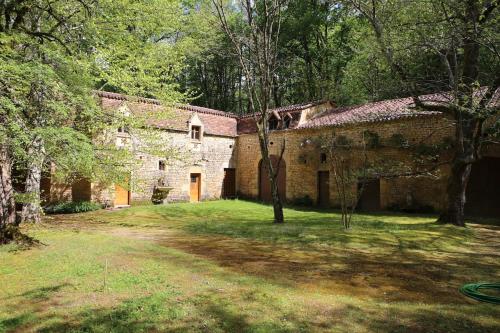 an old stone building in the middle of a yard at Château Les Fournels in Villefranche-du-Périgord