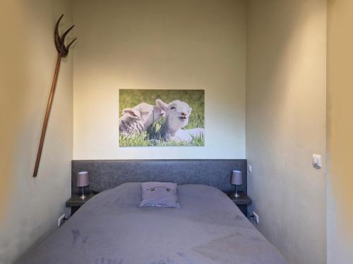 a bed in a room with a picture on the wall at La Garonde in Berthen