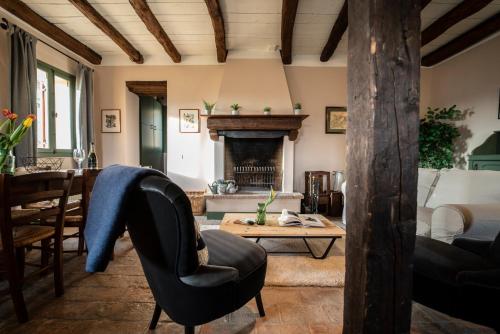 a living room with a fireplace and a table at Foresteria San Rocco Borgoluce in Susegana