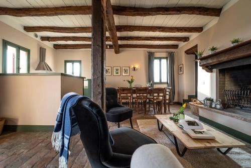 a living room with a fireplace and a table at Foresteria San Rocco Borgoluce in Susegana
