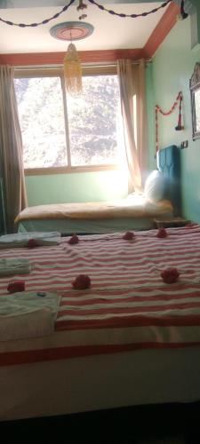 a bedroom with a bed with a window and a bedspread at Atlas Views in Imlil