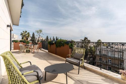 a patio with chairs and a table on a balcony at מלון רמב"ן ירושלים - קבוצת מחניודה in Jerusalem