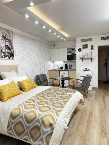 une chambre avec un grand lit et une cuisine dans l'établissement Appartement Monaco Palais Joséphine, à Beausoleil