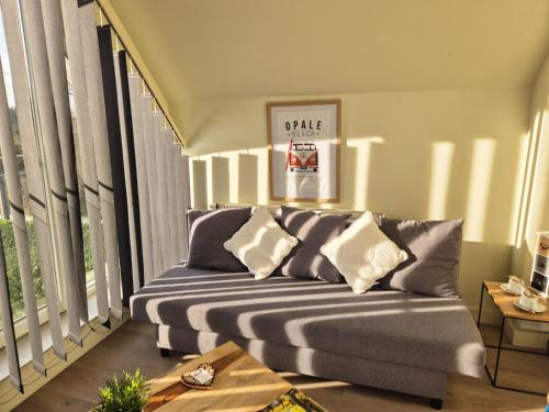 a living room with a couch in front of windows at La Garonde in Berthen