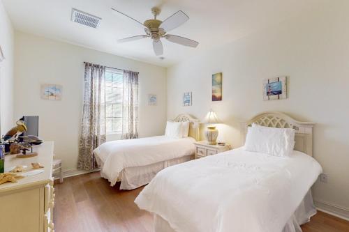 una camera da letto con due letti e un ventilatore a soffitto di Villa Bonita Sol a Naples