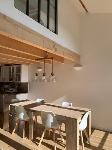 a kitchen and dining room with a wooden table and chairs at La Jassine in Mison