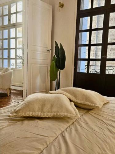 - un lit avec deux oreillers dans une chambre dotée d'une fenêtre dans l'établissement Appartement 45 m2,élégant rénové, centre historique, à Pézenas