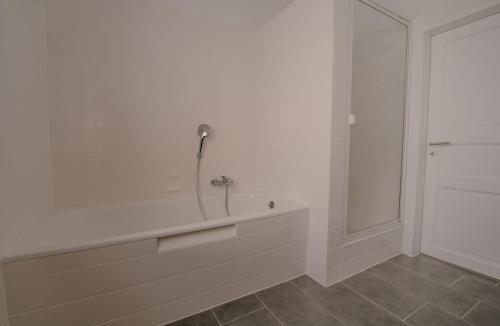 a white bathroom with a tub and a shower at Ferienwohnung Kassel mit Ladesäule & Balkon in Kassel