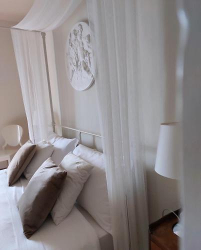a white bed with white curtains and pillows at B&B Palazzo Mattei in Novafeltria