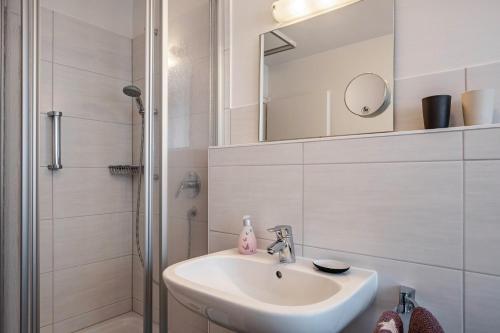 a white bathroom with a sink and a shower at Ferienwohnung Dachtler in Hinterzarten