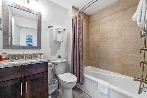 a bathroom with a toilet and a tub and a sink at Serenity at Deerhaven #B & #C in Gold Beach