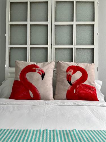 two red flamingos sitting on top of a bed at El Patio del Limonero in Écija