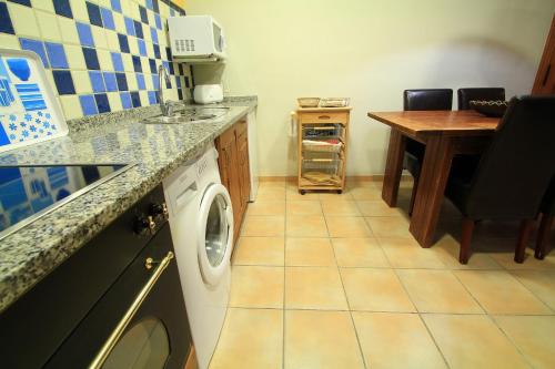 a laundry room with a washing machine and a table at Apartamentos Rurales Los Brezos* in Cotillo